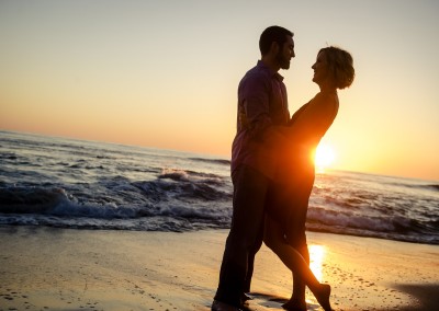 couple silhouette with sunlight behind on beach