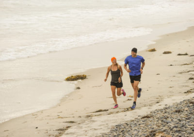 couple athletes jogging on beach