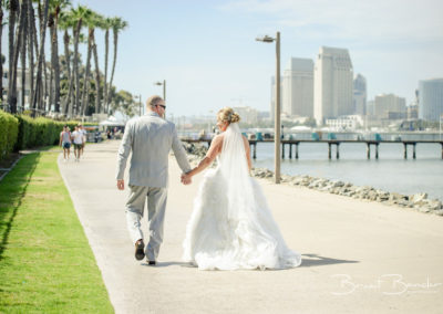 groom and bride walking towards pier brant bender photography