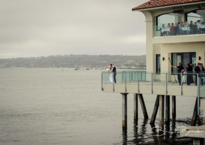bride and groom overlooking beach from lighthouse