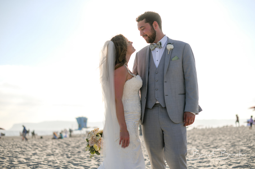 bride and groom smiling on beach being honest with your wedding photographer