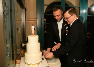 groom and groom cutting wedding cake
