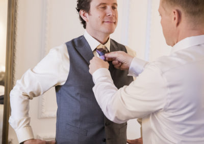 groom getting ready groomsman fixing tie brant bender photography