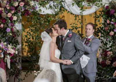 couple kissing in front of red maroon purple pink green wedding colors brant bender photography