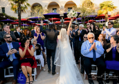 bride and groom walking down aisle with guests cheering prado at balboa park